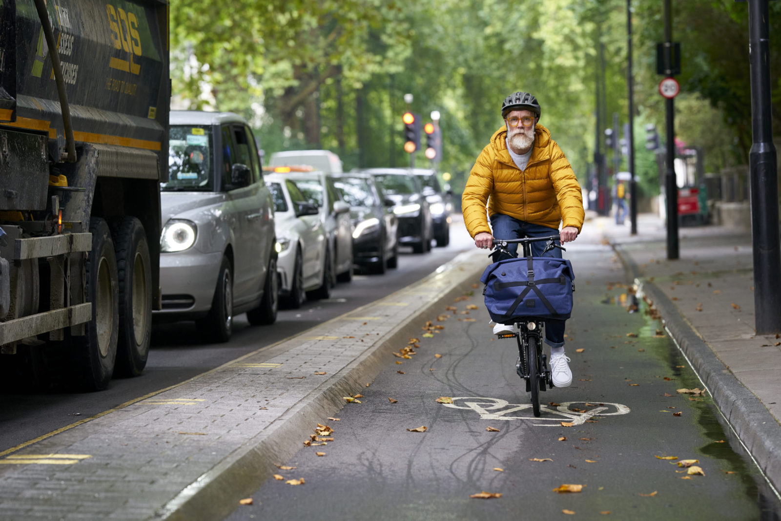 Rowerzysta jadący rowerem Brompton miejskimi ulicami
